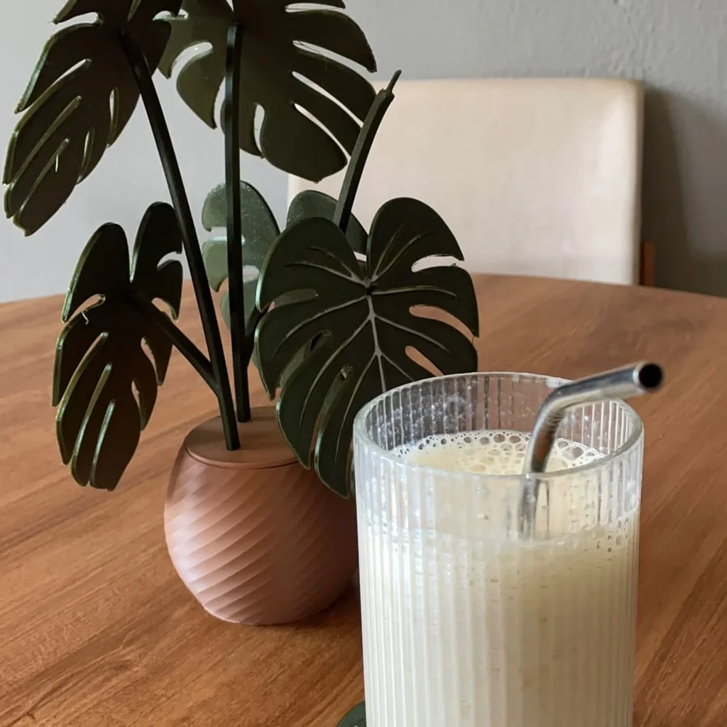 Porta-copos folha com um copo de vitamina, ao lado da planta montada